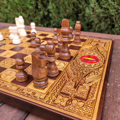 Close-up of ornate walnut chess board with intricate gold engravings, ideal for collectors and gifts.