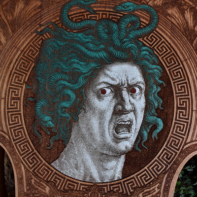 Engraved Medusa head design in violin silhouette, vintage gothic wall piece.