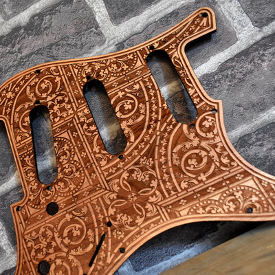 Close-up of laser-engraved flourish pattern on cherry wood pickguard