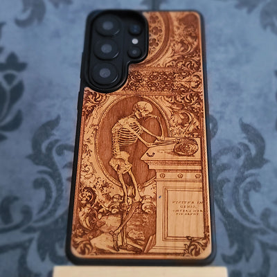 Laser-engraved wooden phone case with a gothic skeleton thinker design, perfect for iPhone and Samsung Galaxy.