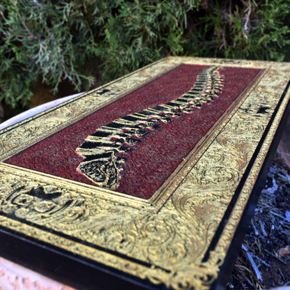 Human spine artwork in red and gold engraved on wood panel