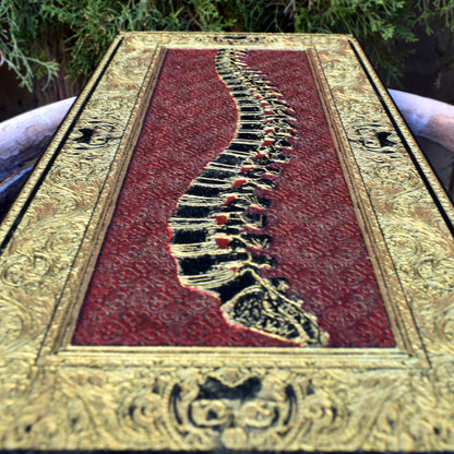 Laser-engraved red spine art on dark wood gothic decor