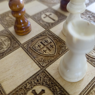 Close-up of a chessboard with ornate design, featuring a wooden pawn and a white bishop.
