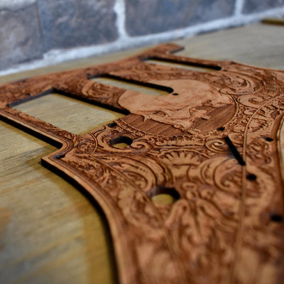 Close-up of skull-engraved cherry wood pickguard for Fender Stratocaster guitar