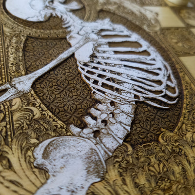 Engraved wood chessboard with skull and bone motifs