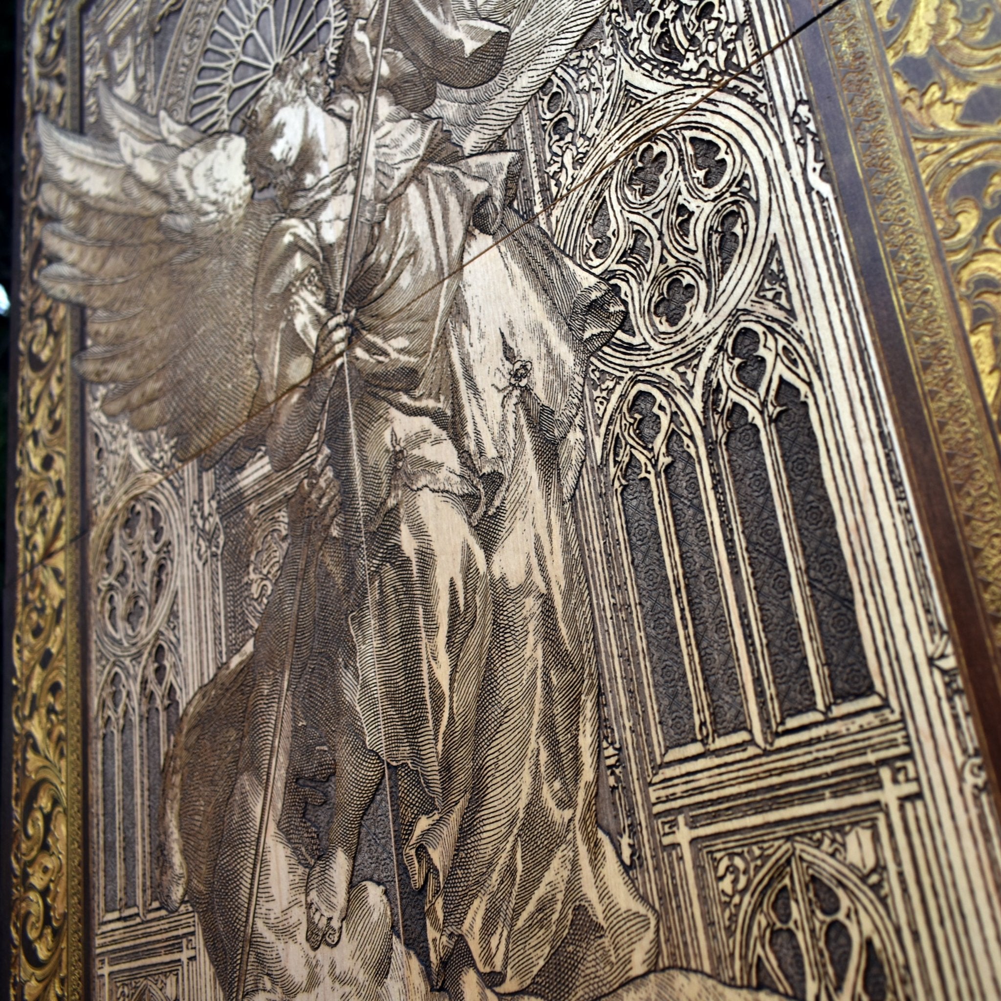 Close-up view of the finely engraved St. Michael the Archangel, highlighting intricate details on stained maple wood.