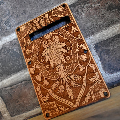 Close-up of laser engraved cherry wood tremolo cover for Fender Stratocaster SSS & HSS models.