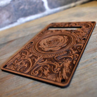 Close-up of laser-engraved cherry wood tremolo cover for Stratocaster guitars