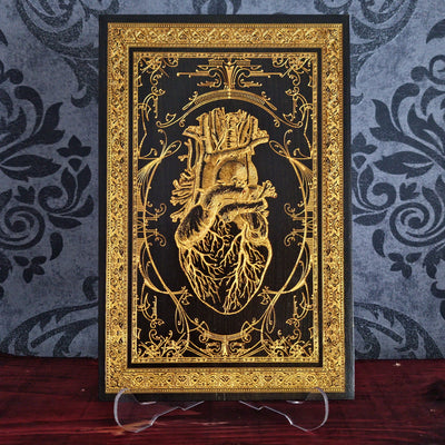 Black anatomical heart wood wall art, engraved for gothic or romantic decor.