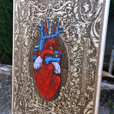Side view of the wooden anatomical heart wall art, highlighting the thickness and natural grain of the maple wood with its hand-painted artistic details.