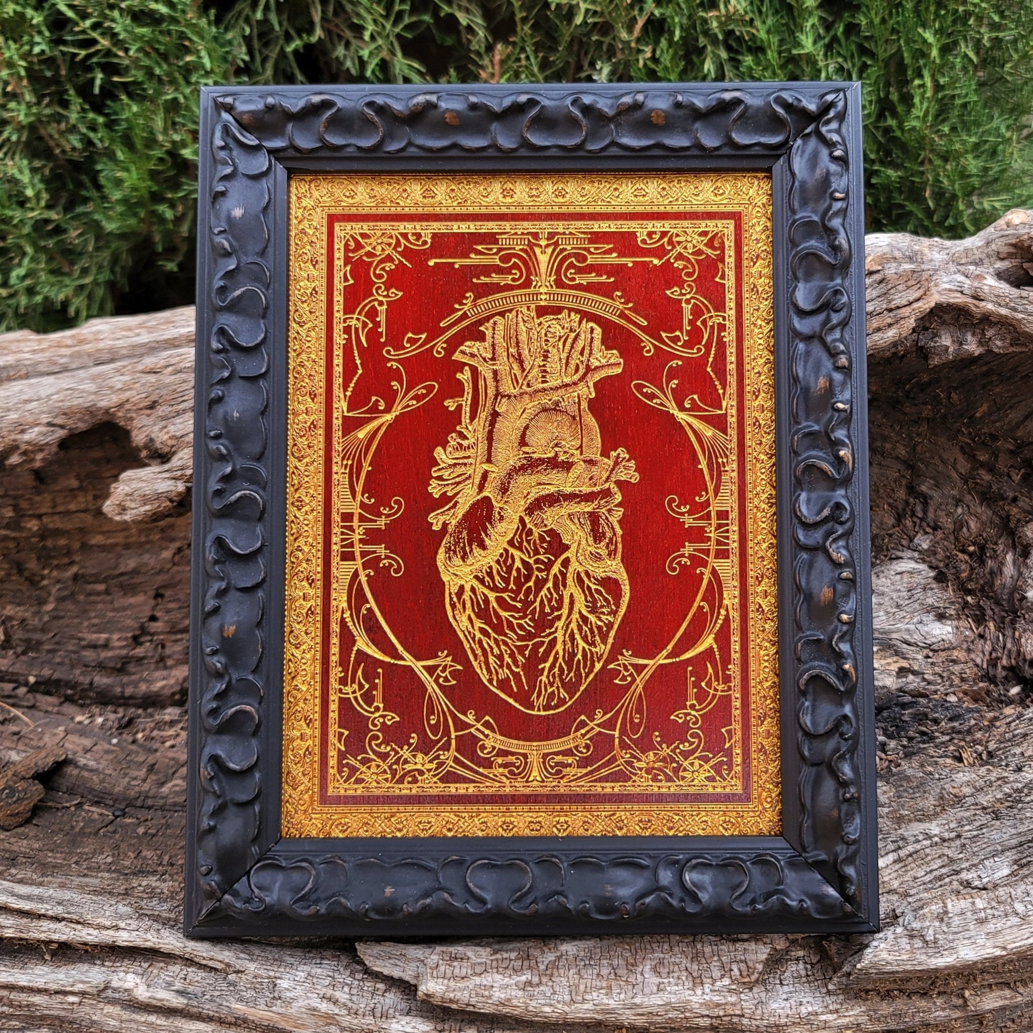 Red anatomical heart painting on a wooden plaque, detailed with gold accents.
