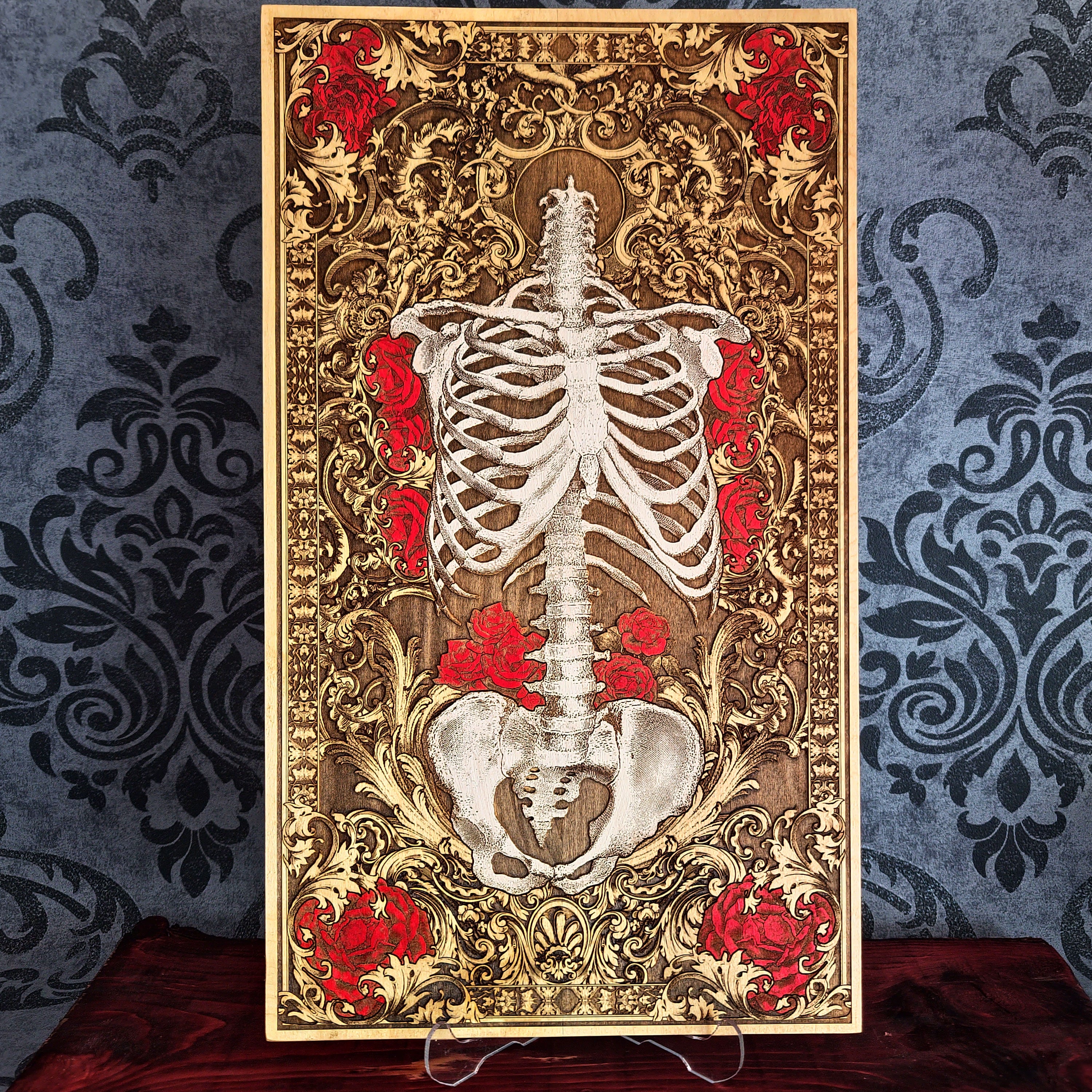 Decorative panel with a skeleton and red flowers on an ornate gold background