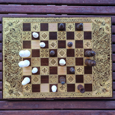 Handcrafted luxury chessboard with ornate laser engraving on wood-stained finish – perfect 5-year anniversary gift.
