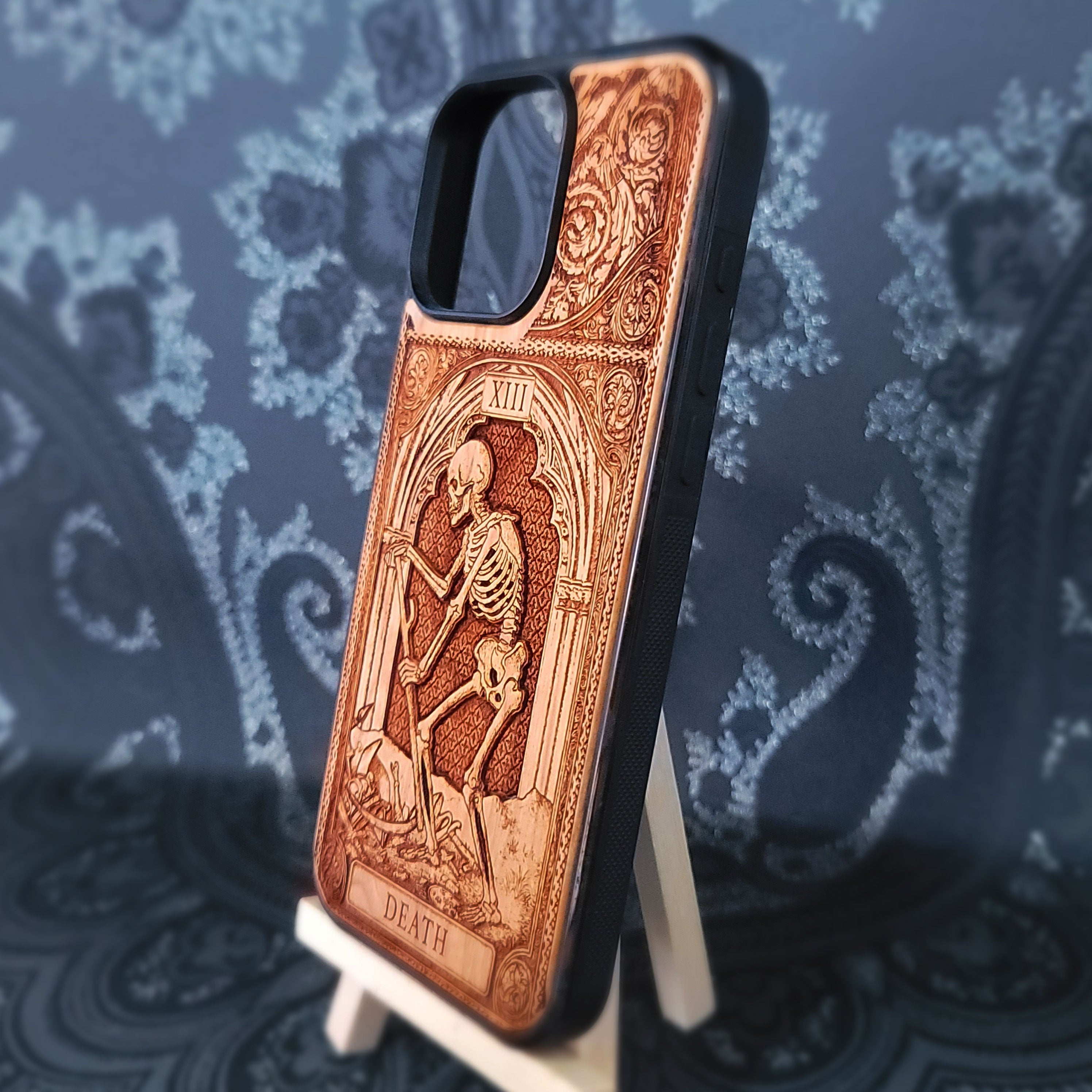 Deep laser engraved wooden phone case featuring the Death tarot card with gothic mystical details on natural wood for iPhone and Samsung Galaxy models.