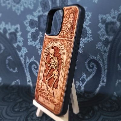 Deep laser engraved wooden phone case featuring the Death tarot card with gothic mystical details on natural wood for iPhone and Samsung Galaxy models.