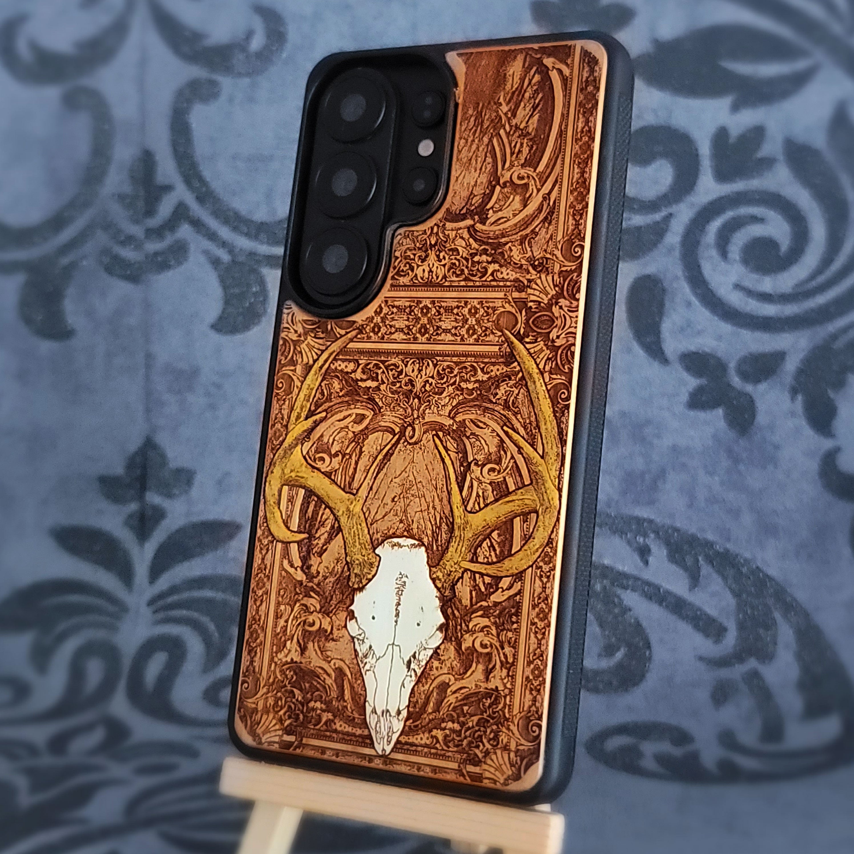 Phone case with deer skull design on a decorative background