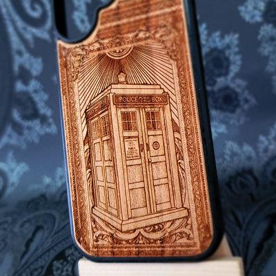 Deep laser engraved wooden phone case featuring a doctor who police box inspired sci-fi design on natural wood for iPhone and Samsung Galaxy models.