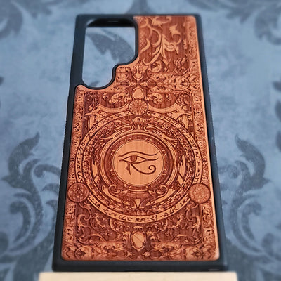 Handcrafted wooden phone case featuring a laser-engraved Eye of Horus Ra symbol. Perfect for lovers of Egyptian mythology and artistic designs. 