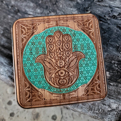 Wireless charger with sacred Hamsa symbol on artisan wood.