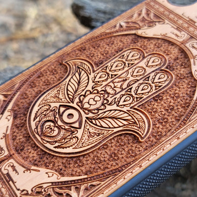 Wooden phone case featuring a beautifully intricate Hamsa hand design, intricately laser-engraved with fine detailing. The design is symbolic of protection, peace, and good fortune. Compatible with iPhone , 15, 14, 13, 12, 11 Pro Max Mini and Samsung Galaxy S, S24, S23, S22, S21, S20 Ultra, Plus, and Note 20. A unique and durable accessory perfect for those seeking a meaningful and stylish phone case.