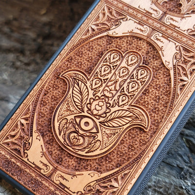 Wooden phone case featuring a beautifully intricate Hamsa hand design, intricately laser-engraved with fine detailing. The design is symbolic of protection, peace, and good fortune. Compatible with iPhone , 15, 14, 13, 12, 11 Pro Max Mini and Samsung Galaxy S, S24, S23, S22, S21, S20 Ultra, Plus, and Note 20. A unique and durable accessory perfect for those seeking a meaningful and stylish phone case.