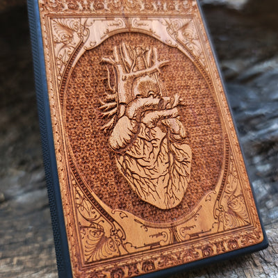 Gothic wooden phone case featuring an anatomical human heart design, intricately engraved. Compatible with iPhone , iPhone 15, Galaxy S, Note 20, and other models. Ideal for fans of gothic and anatomical art.