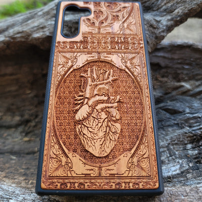 Gothic wooden phone case featuring an anatomical human heart design, intricately engraved. Compatible with iPhone , iPhone 15, Galaxy S, Note 20, and other models. Ideal for fans of gothic and anatomical art.