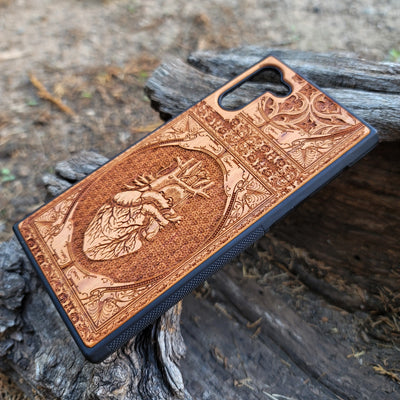 Gothic wooden phone case featuring an anatomical human heart design, intricately engraved. Compatible with iPhone , iPhone 15, Galaxy S, Note 20, and other models. Ideal for fans of gothic and anatomical art.
