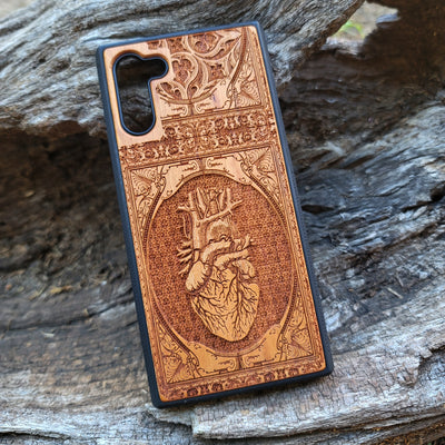 Gothic wooden phone case featuring an anatomical human heart design, intricately engraved. Compatible with iPhone , iPhone 15, Galaxy S, Note 20, and other models. Ideal for fans of gothic and anatomical art.