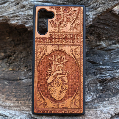 Gothic wooden phone case featuring an anatomical human heart design, intricately engraved. Compatible with iPhone , iPhone 15, Galaxy S, Note 20, and other models. Ideal for fans of gothic and anatomical art.