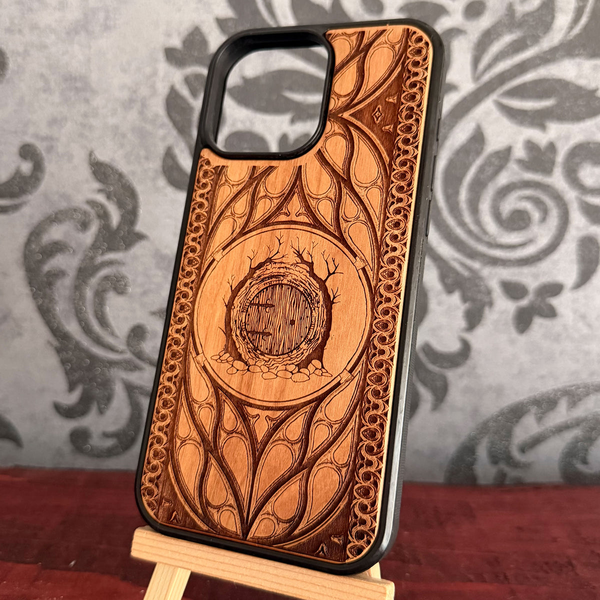 Round wooden fantasy door surrounded by tree roots laser engraved on cherrywood case