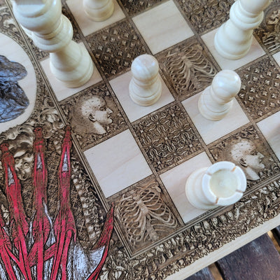 Close-up of laser-engraved medical illustrations on ornate wood chess board.