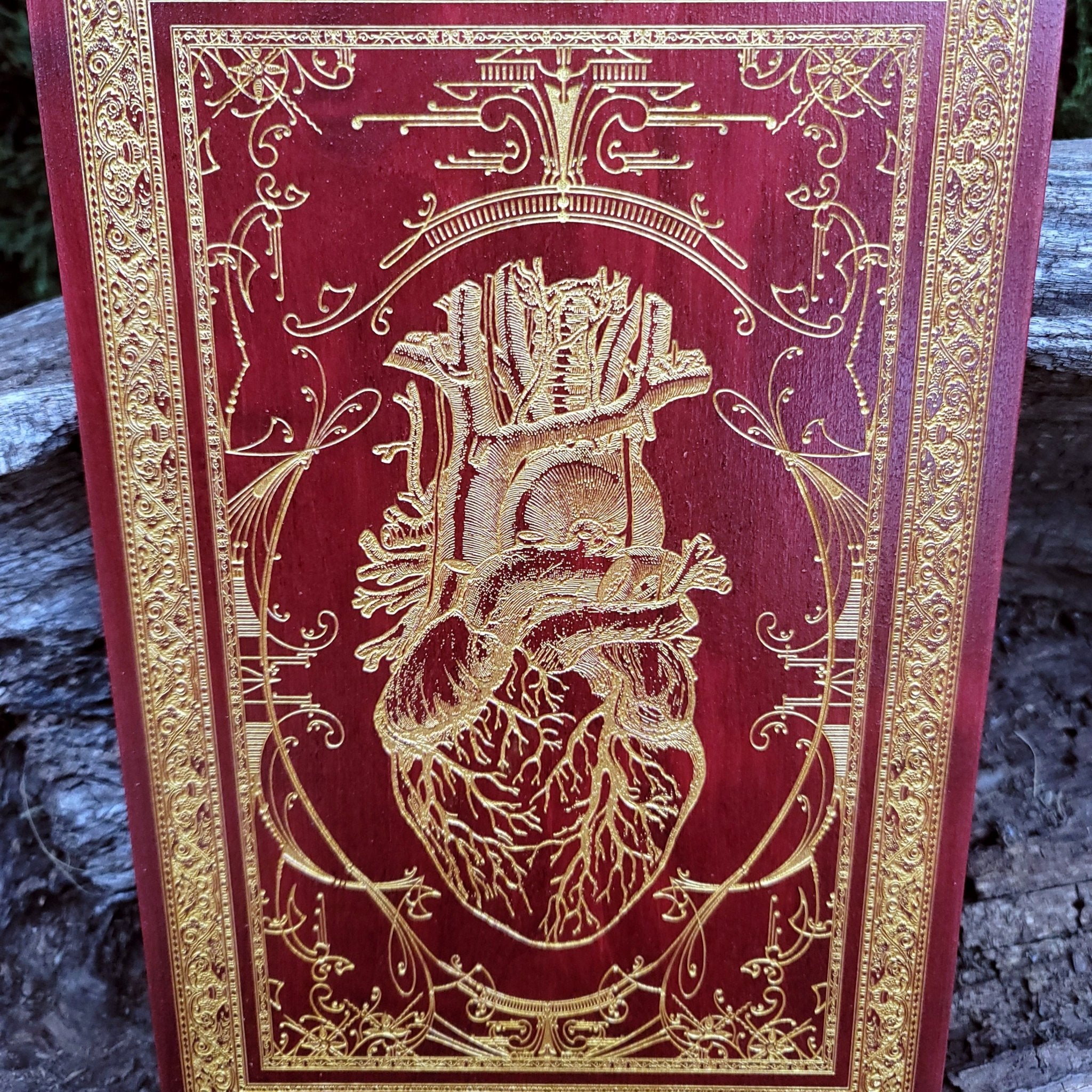 Gothic-style red heart art on natural wood, engraved with anatomical accuracy.