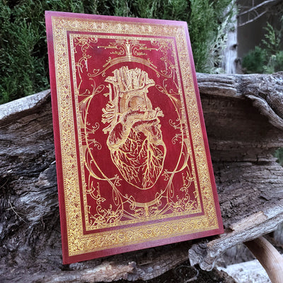 Wood wall decor featuring red engraved anatomical heart with realistic detail.