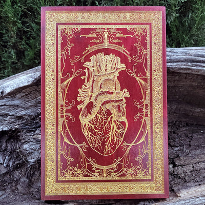 Anatomical human heart engraved in red on wood, gothic wall art for anatomy lovers.