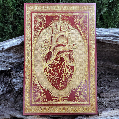 Red anatomical heart engraved on wood, gothic wall art for horror lovers.