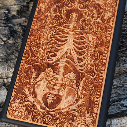 Wooden phone case with a detailed human skeleton torso and roses design, engraved for iPhone 16, iPhone 15, Galaxy S23 Ultra, Note 20, and more. Perfect for gothic art lovers seeking a unique phone accessory.