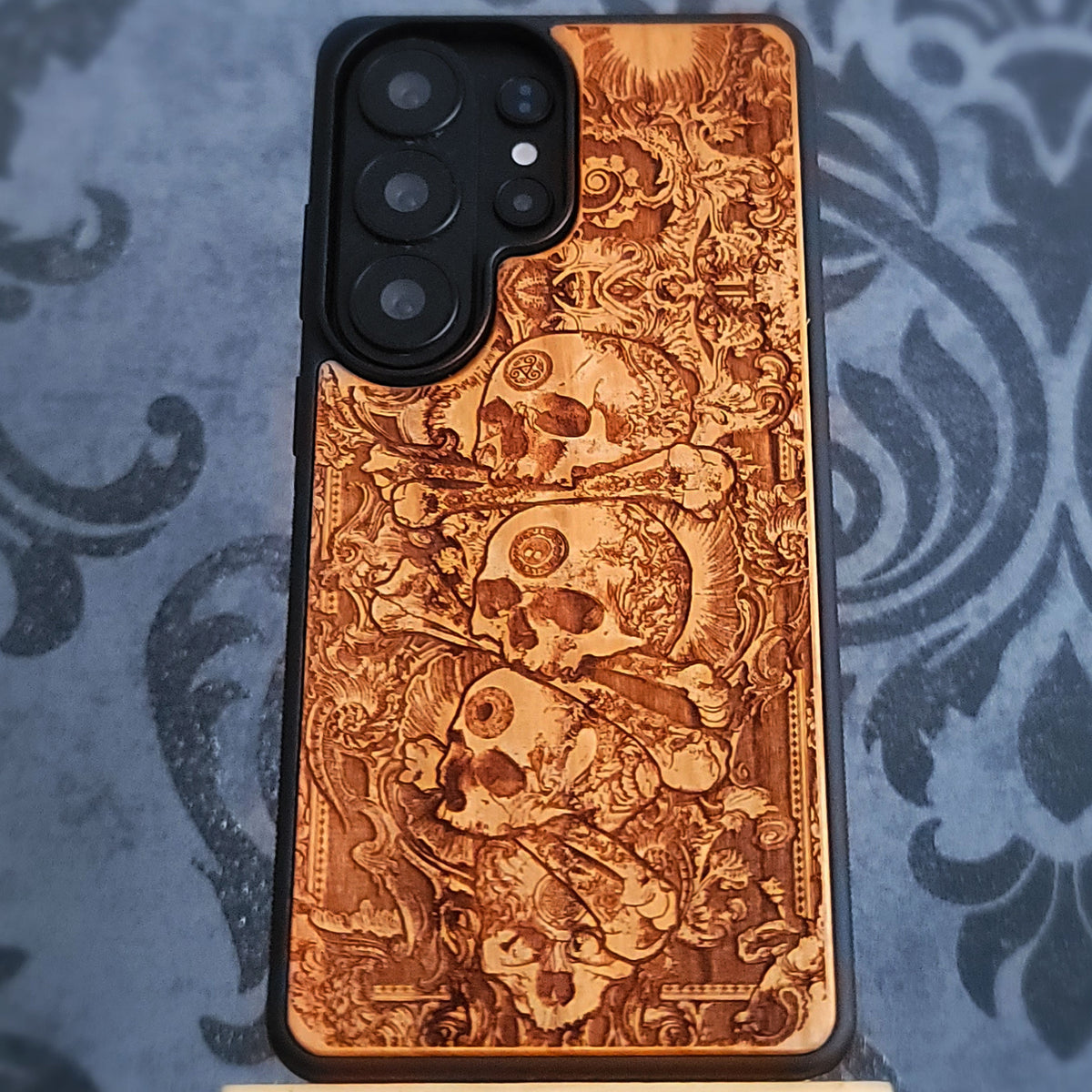 Dark gothic skull phone case with detailed laser engraving on natural wood