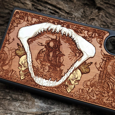 Close-up of handcrafted cherry wood phone case featuring a detailed shark engraving.