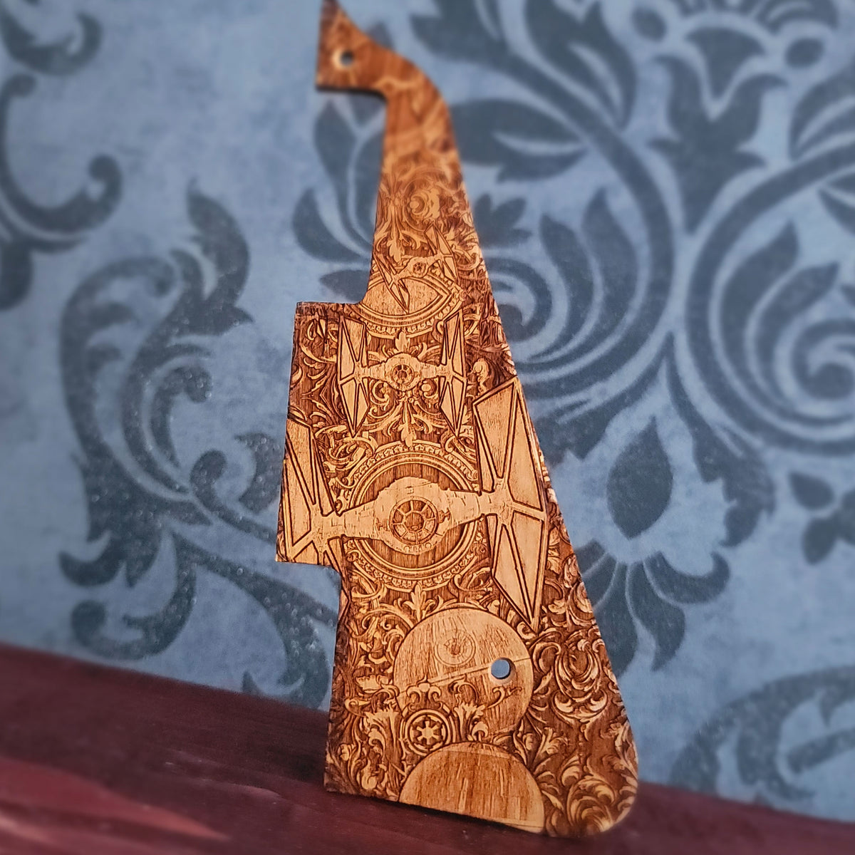 Wooden guitar pickguard with futuristic starfighters and ornate galactic laser engraved design