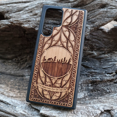 Lord of the Rings wood phone case featuring the Fellowship of the Ring silhouette, intricate Elvish-inspired patterns, and the engraved quote 'The Road Goes Ever On And On.' Laser-engraved for detailed artistry and durability. Compatible with iPhone , 15, 14, 13, 12, 11, Pro Max, Mini, and Samsung Galaxy S, S24, S23, S22, S21, S20 Ultra, Plus, Note 20. A unique and protective accessory for Tolkien fans.