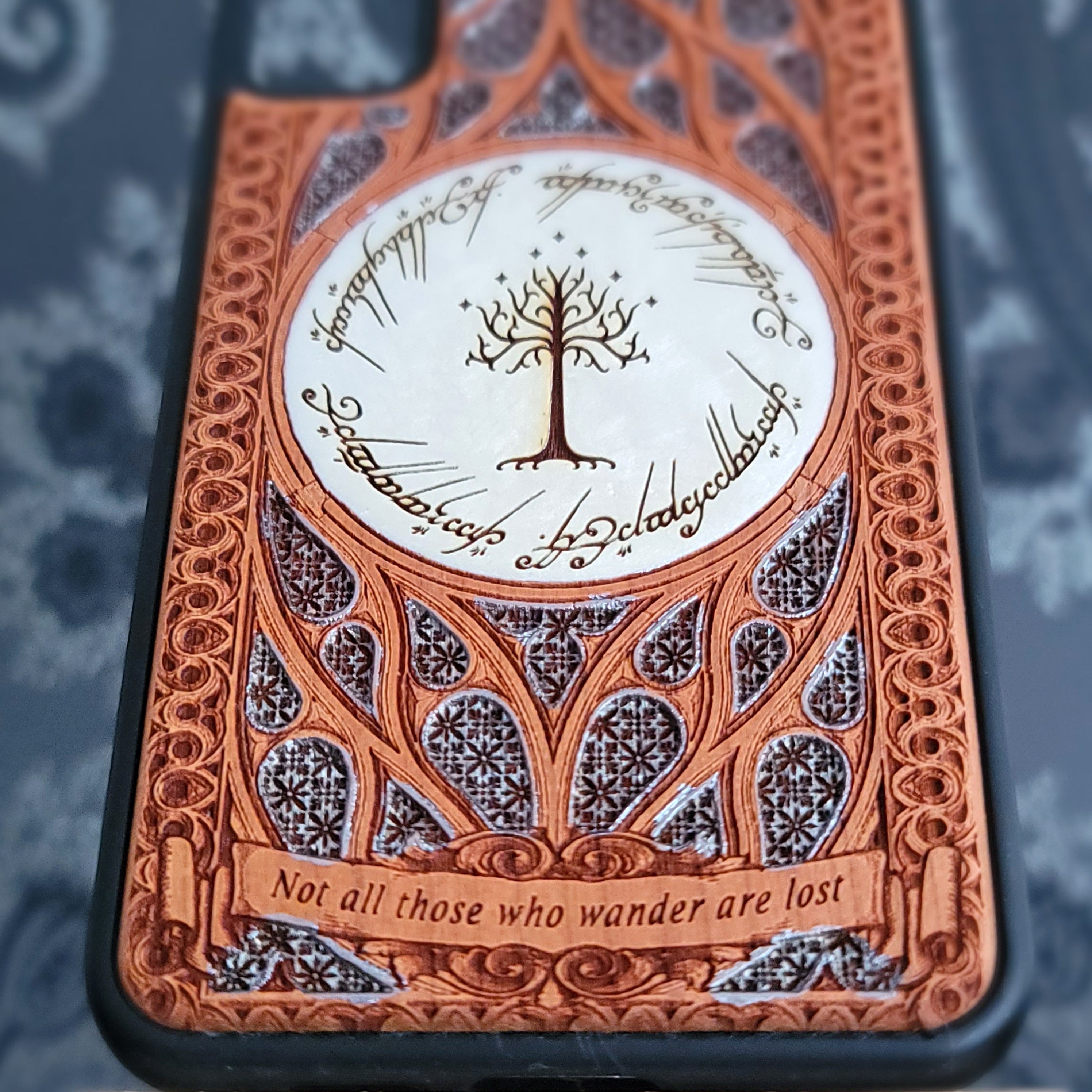 Phone case with intricate design and text on a dark background
