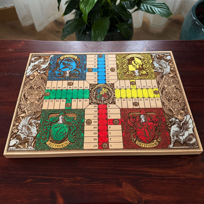 Harry Potter board game featuring four Hogwarts houses with detailed engraved fantasy artwork
