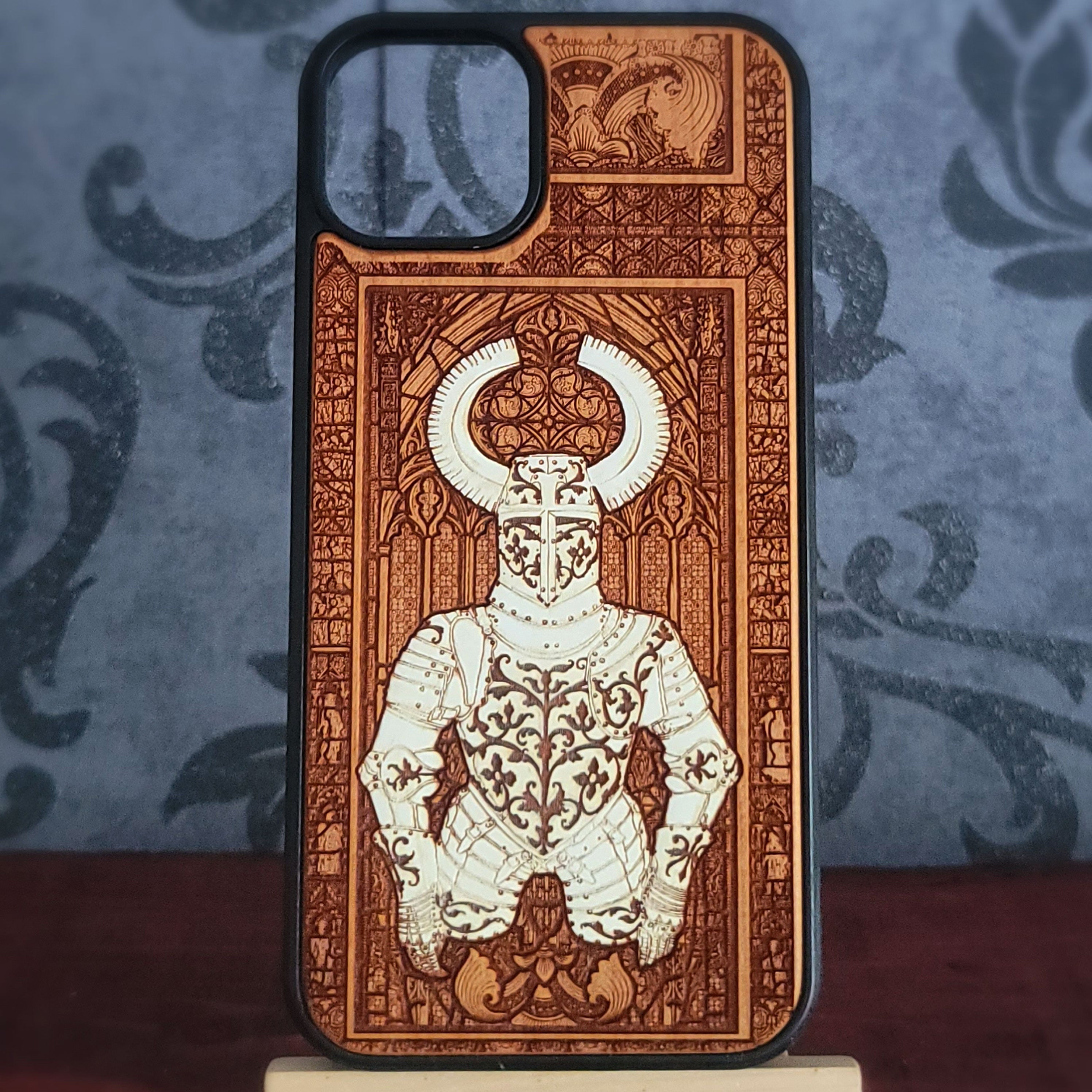 A phone case featuring a highly detailed, laser-engraved design of a horned knight in armor, styled like an old book illustration. 