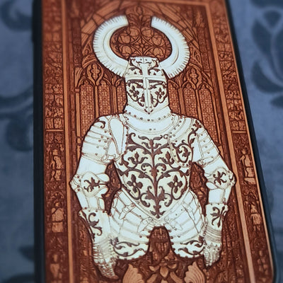 A close-up of a decorative printed panel or card featuring a stylized knight in ornate armor with a horned helmet,
