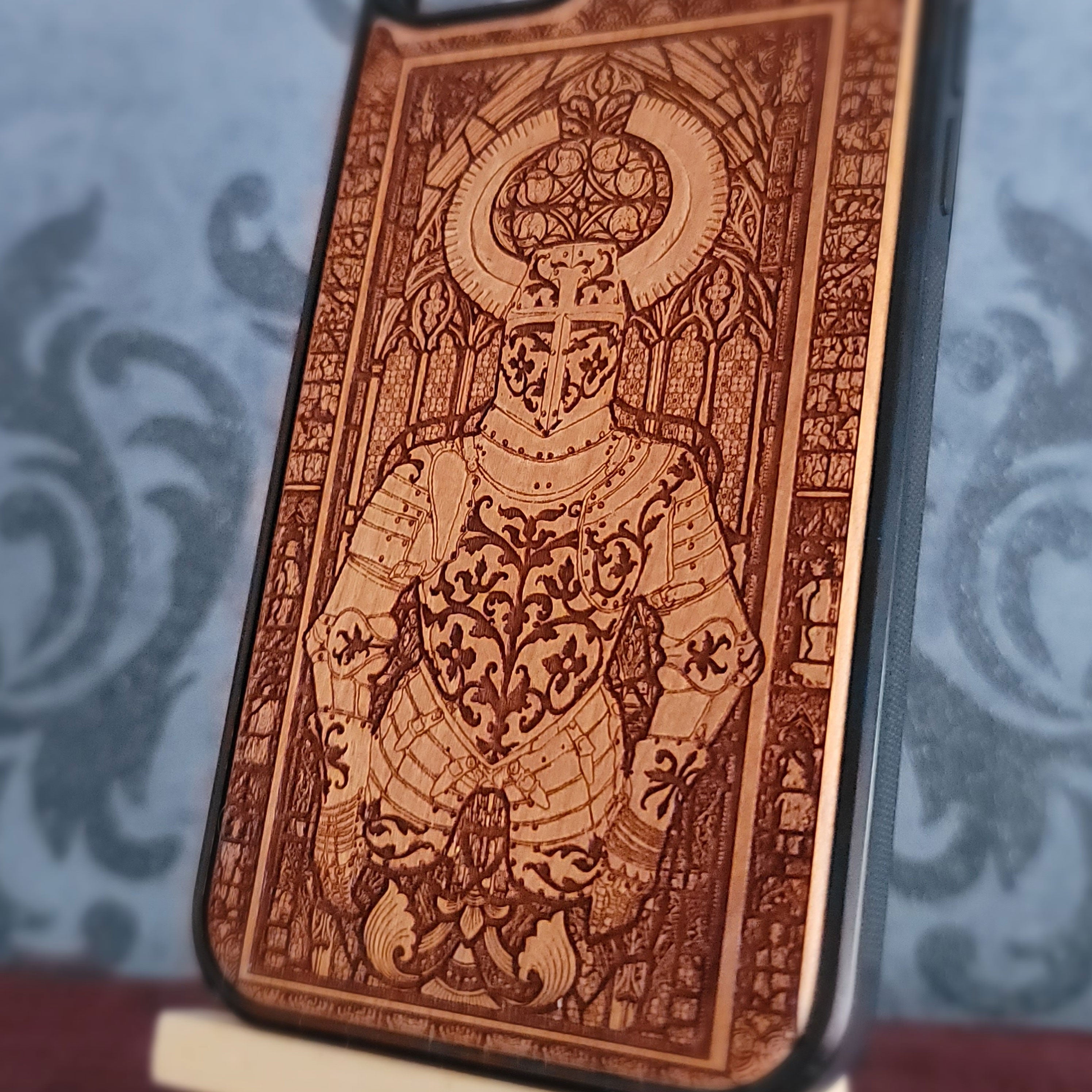 A close-up of a phone case featuring an intricate laser-engraved knight in armor design