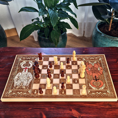 An ornate rectangular chessboard with decorative engraved or painted borders and matching chess pieces 