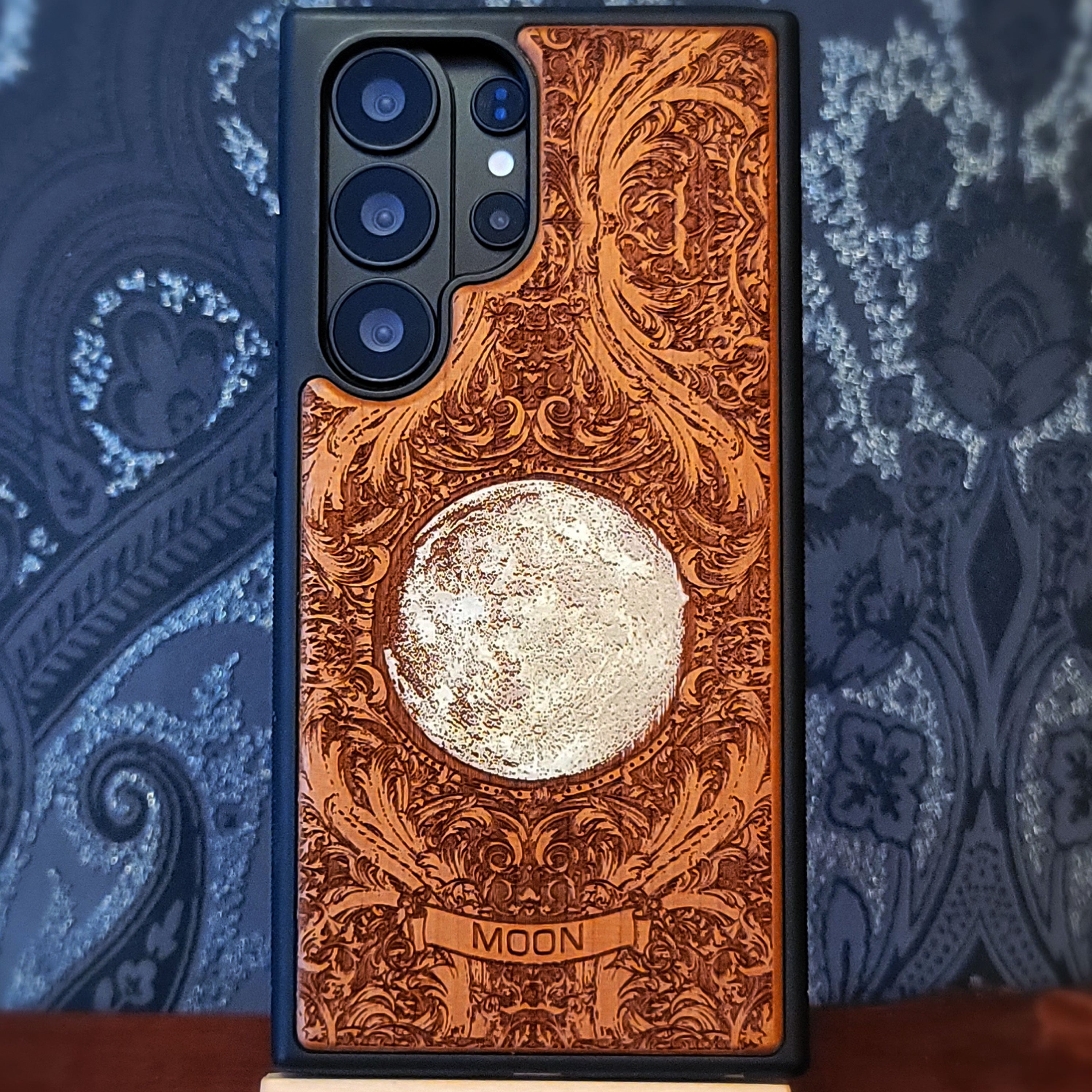 Hand painted silver moon wooden phone case with deep laser engraved celestial artwork for iPhone and Samsung Galaxy models.