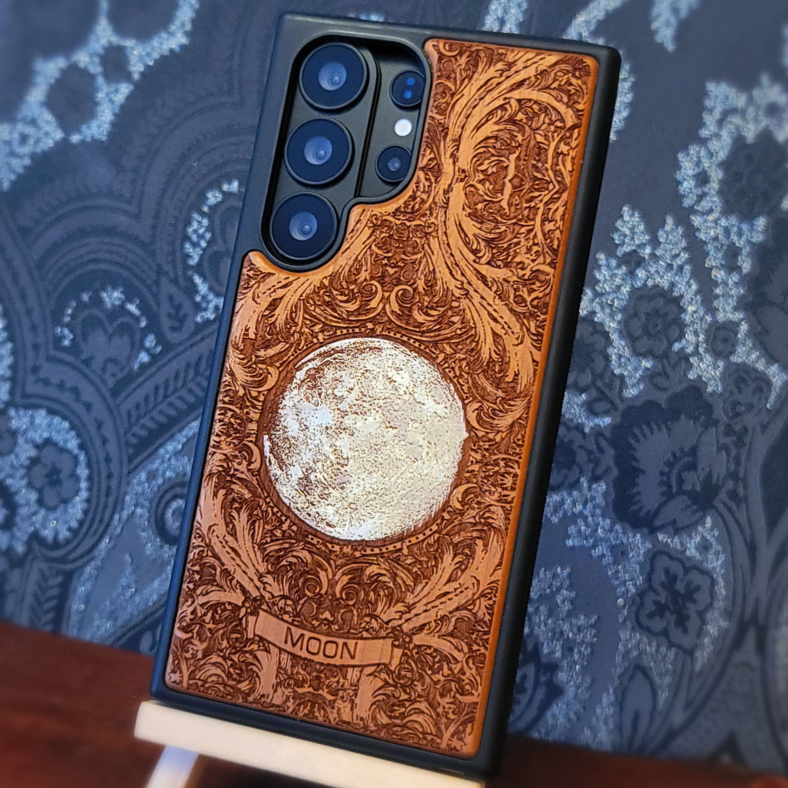 Hand painted silver moon wooden phone case with deep laser engraved celestial artwork for iPhone and Samsung Galaxy models.