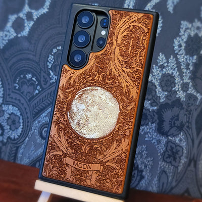 Hand painted silver moon wooden phone case with deep laser engraved celestial artwork for iPhone and Samsung Galaxy models.